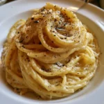 Piatto di spaghetti cacio e pepe con formaggio e pepe nero