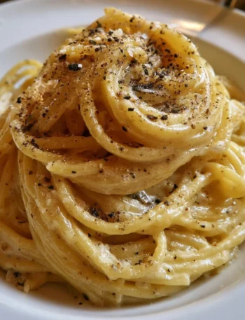 Piatto di spaghetti cacio e pepe con formaggio e pepe nero