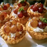 Tartellette con uva, caprino e miele su un piatto elegante